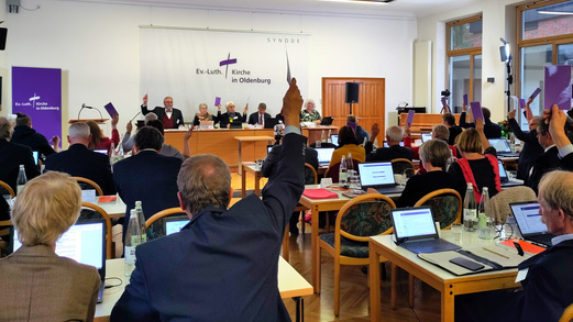 Synodale stimmen bei einer Tagung ab.