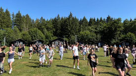 Viele Jugendliche laufen über eine große Wiese