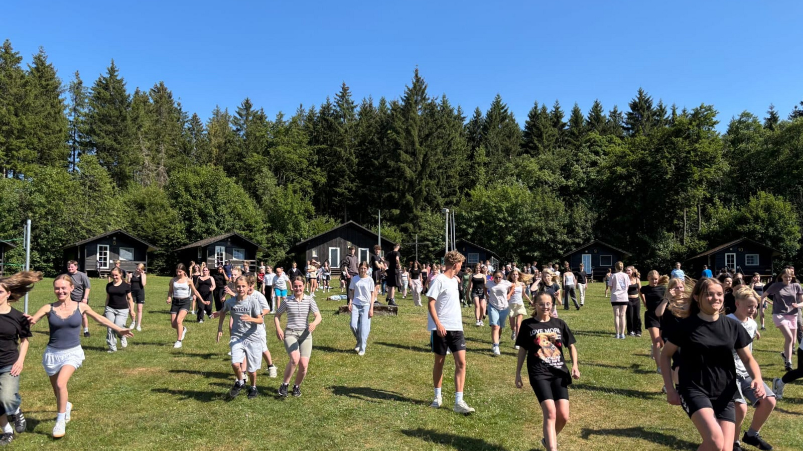 Viele Jugendliche laufen über eine große Wiese